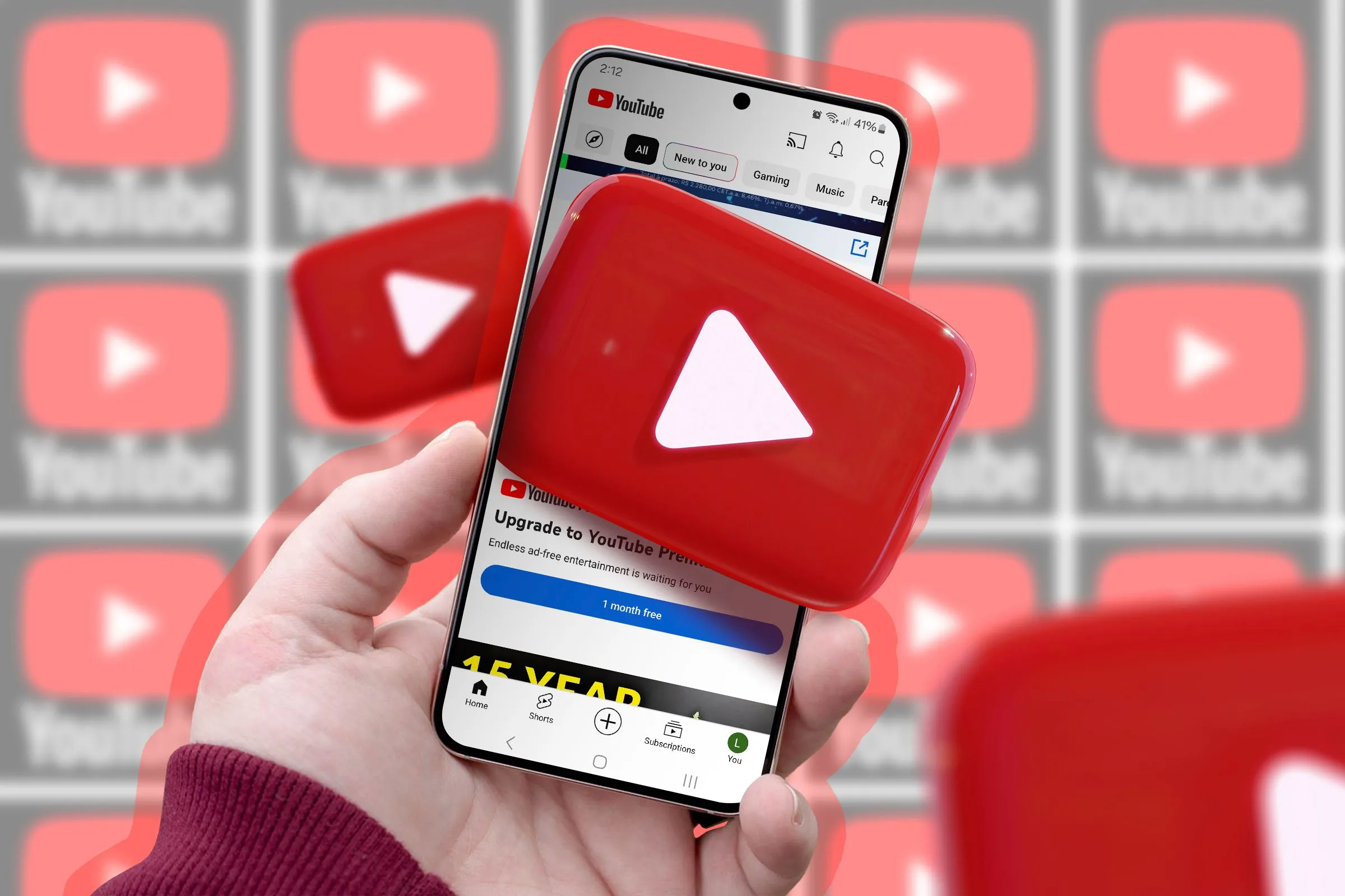 Bàn tay cầm điện thoại hiển thị logo YouTube, minh họa trải nghiệm người dùng với các tính năng mới trên nền tảng.