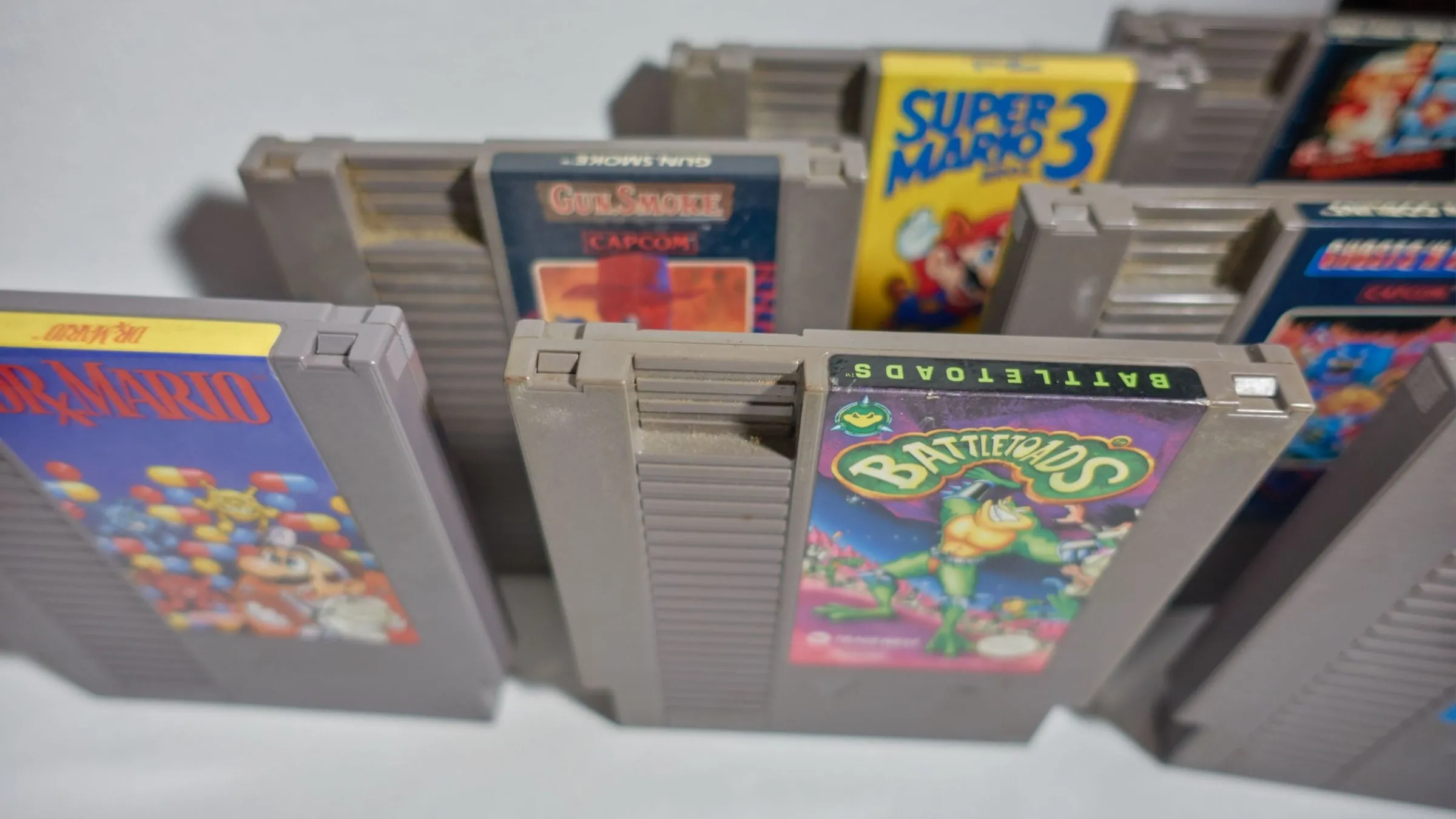 Các băng game NES màu xám đặc trưng, minh họa sự khác biệt về kích thước so với băng Famicom.