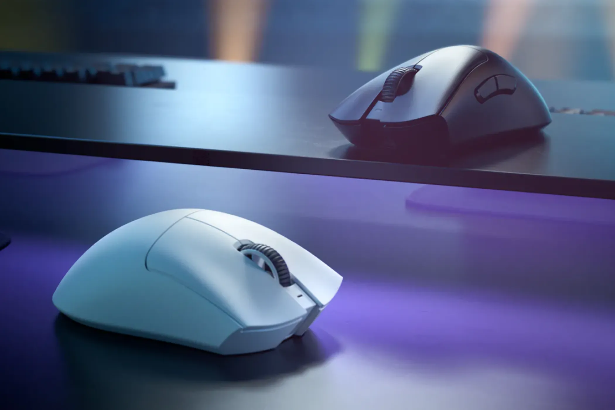 Các phiên bản chuột gaming Razer DeathAdder V3 Pro màu đen và trắng đặt trên bàn, nổi bật với hình dáng công thái học.