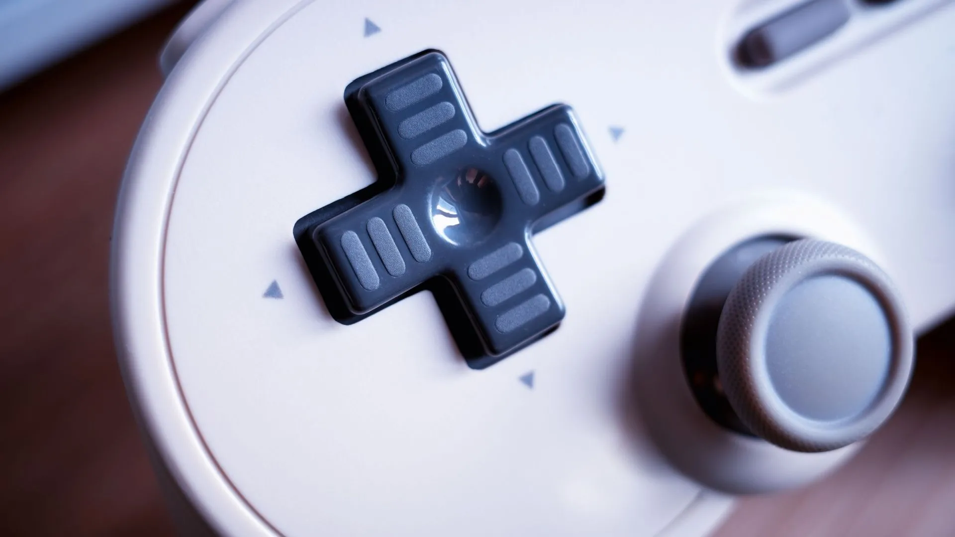 Cận cảnh nút điều hướng D-Pad kinh điển trên tay cầm chơi game, biểu tượng cho phát minh D-Pad của Nintendo, ảnh hưởng đến mọi tay cầm hiện đại.