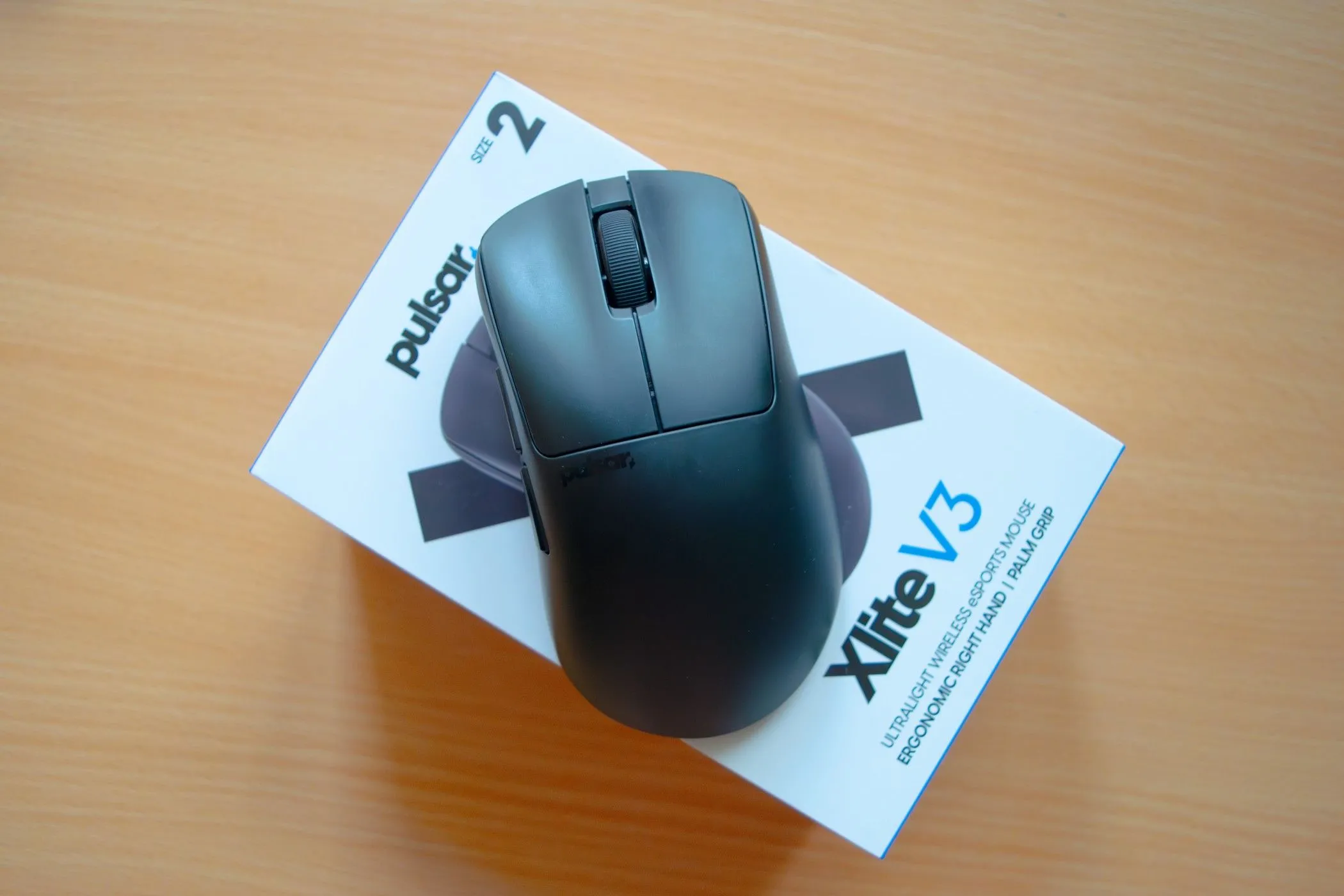 Chuột Pulsar Xlite V3 màu trắng đặt trên hộp đựng ban đầu của nó, cho thấy thiết kế tổng thể và màu sắc