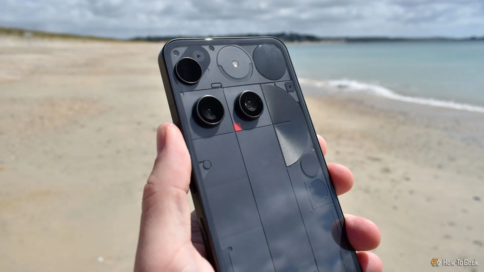 Cụm camera sau và thiết kế mặt lưng trong suốt của Nothing Phone (3) trên bãi biển