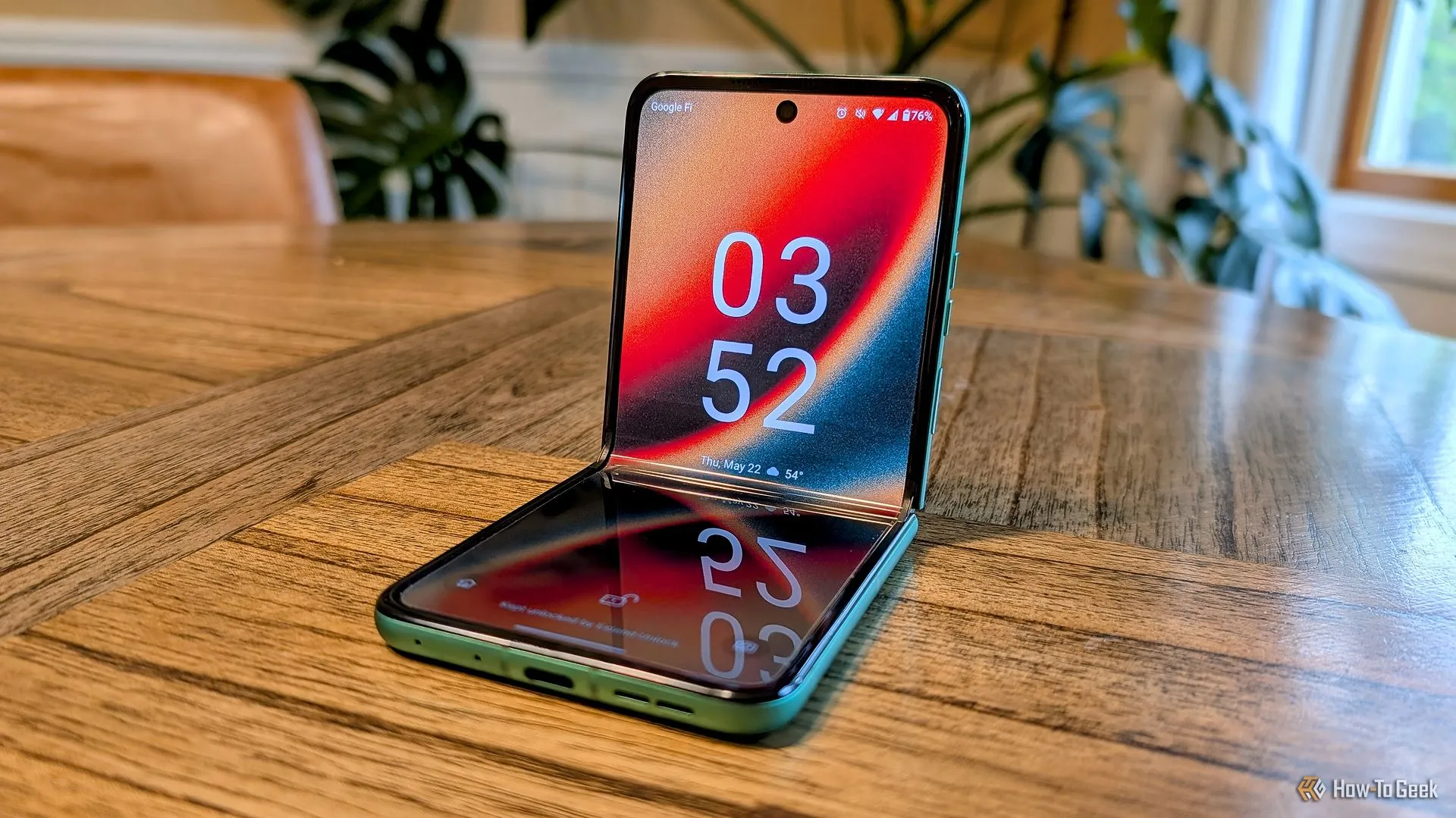 Điện thoại Motorola Razr 2025 màu xanh lá mở gập trên bàn