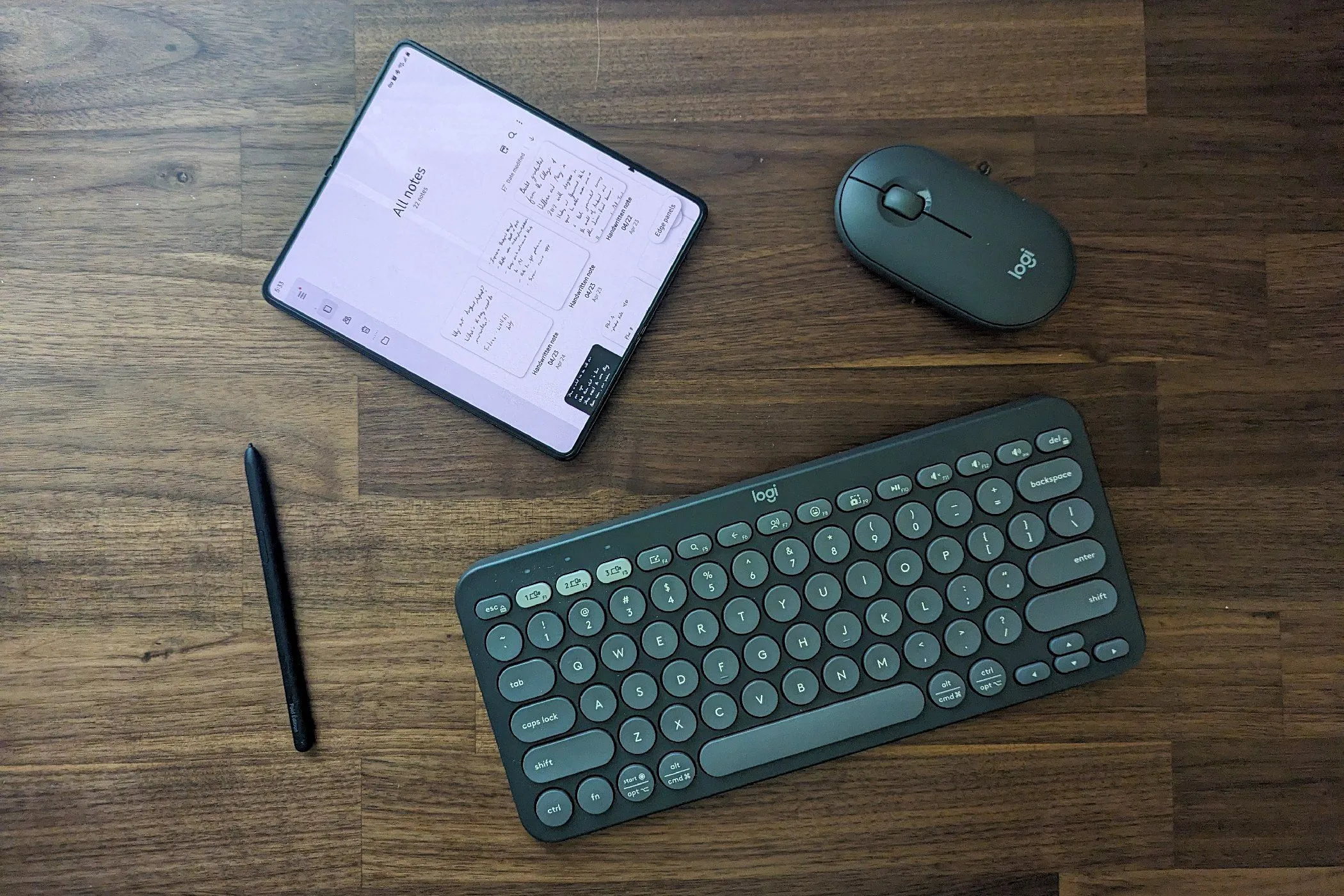 Điện thoại Samsung Galaxy Z Fold 5 cùng với các phụ kiện đi kèm như S Pen và bàn phím Bluetooth.
