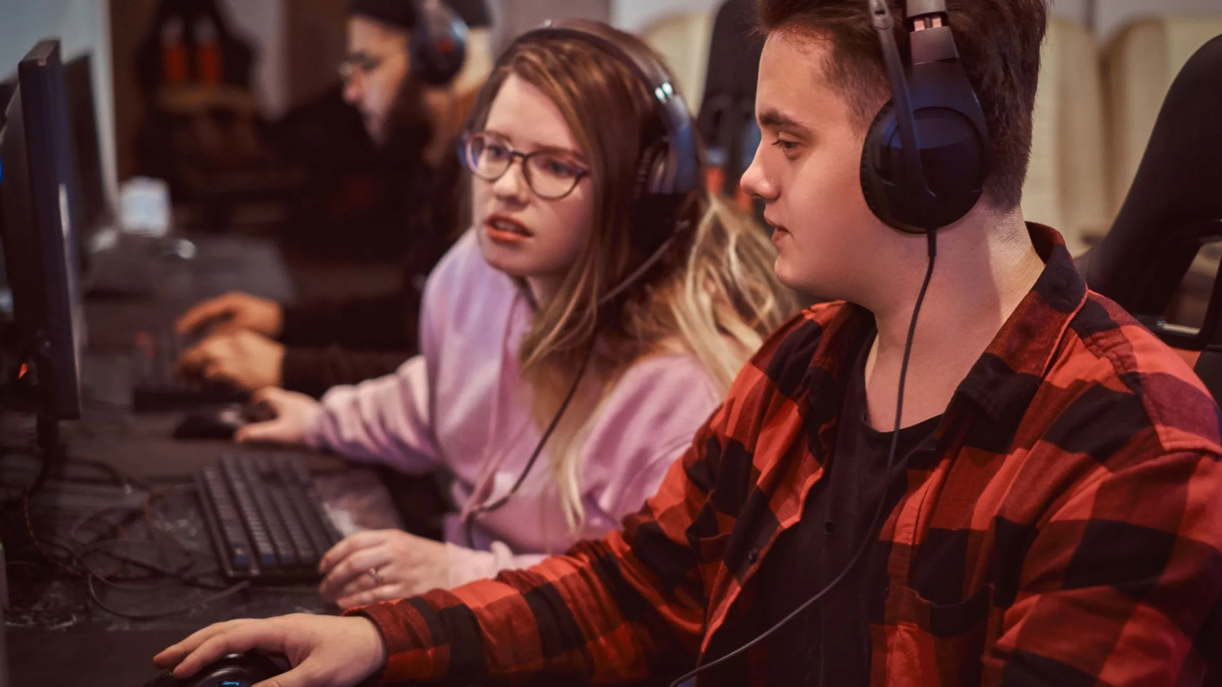 Đội game thủ thiếu niên chơi game nhiều người chơi trên máy tính tại một câu lạc bộ game.