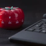 Đồng hồ Pomodoro cổ điển bên cạnh máy tính xách tay