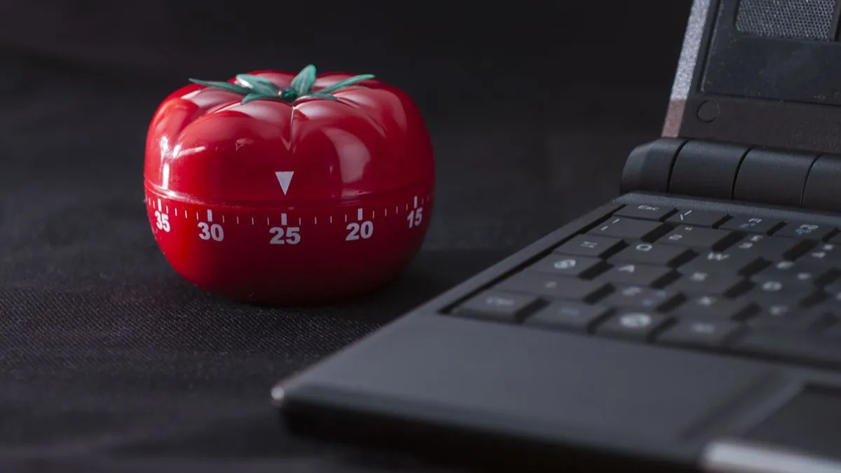Đồng hồ Pomodoro cổ điển bên cạnh máy tính xách tay