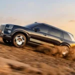 Hình ảnh bên hông mẫu SUV điện Zeekr 9X màu trắng đang di chuyển trên địa hình sa mạc, thể hiện khả năng vượt địa hình và thiết kế sang trọng của xe