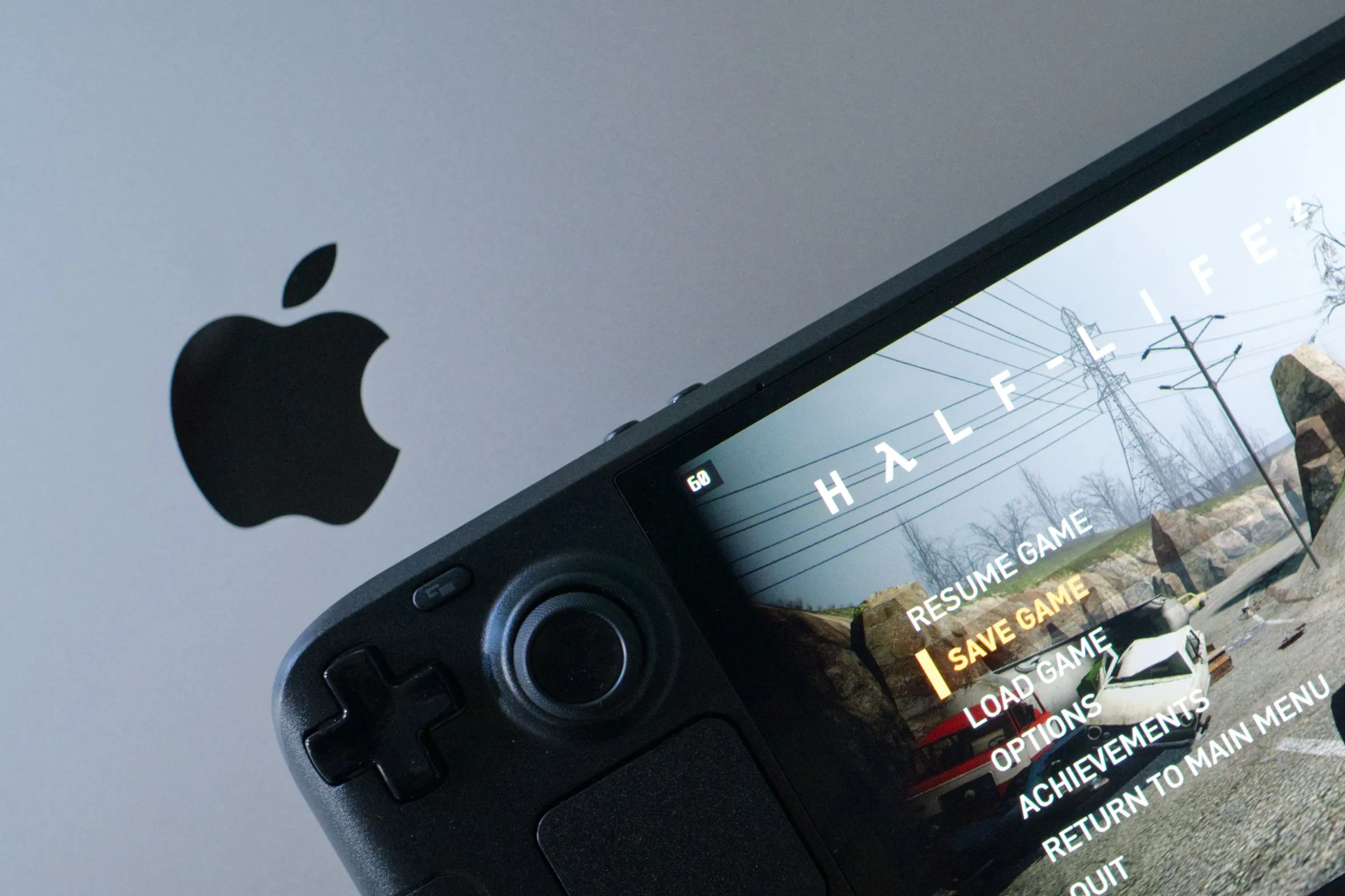 Hình ảnh Half-Life 2 đang hiển thị trên màn hình Steam Deck OLED được đặt trên một chiếc MacBook Pro, tạo nên một khung cảnh công nghệ hiện đại và linh hoạt