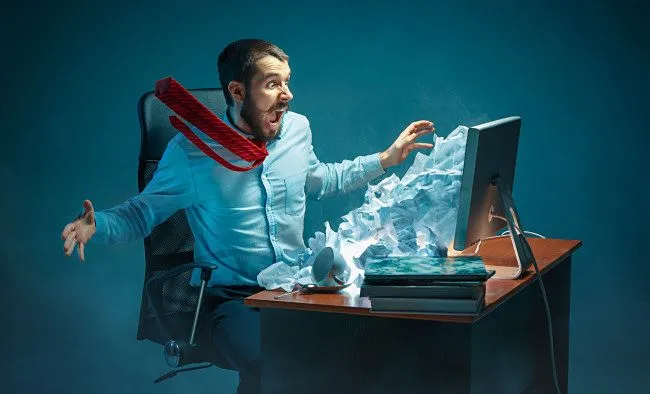Hình ảnh minh họa người đàn ông khó chịu vì thư rác (spam email) trên màn hình máy tính.