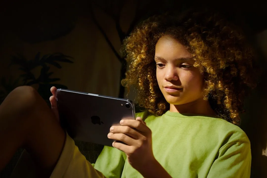 Hình ảnh một đứa trẻ đang sử dụng iPad với tài khoản Apple riêng.