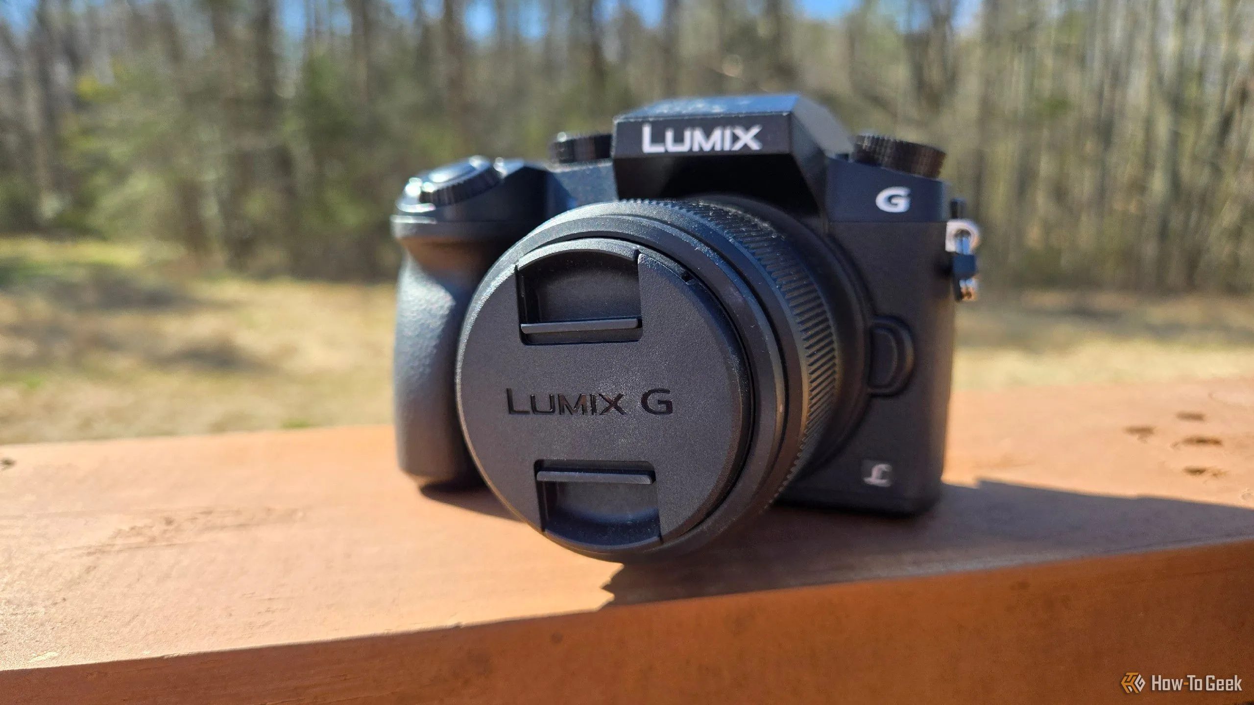 Máy ảnh mirrorless Panasonic Lumix G7 đặt trên lan can, đối thủ cạnh tranh về chất lượng ảnh với camera điện thoại hiện đại.