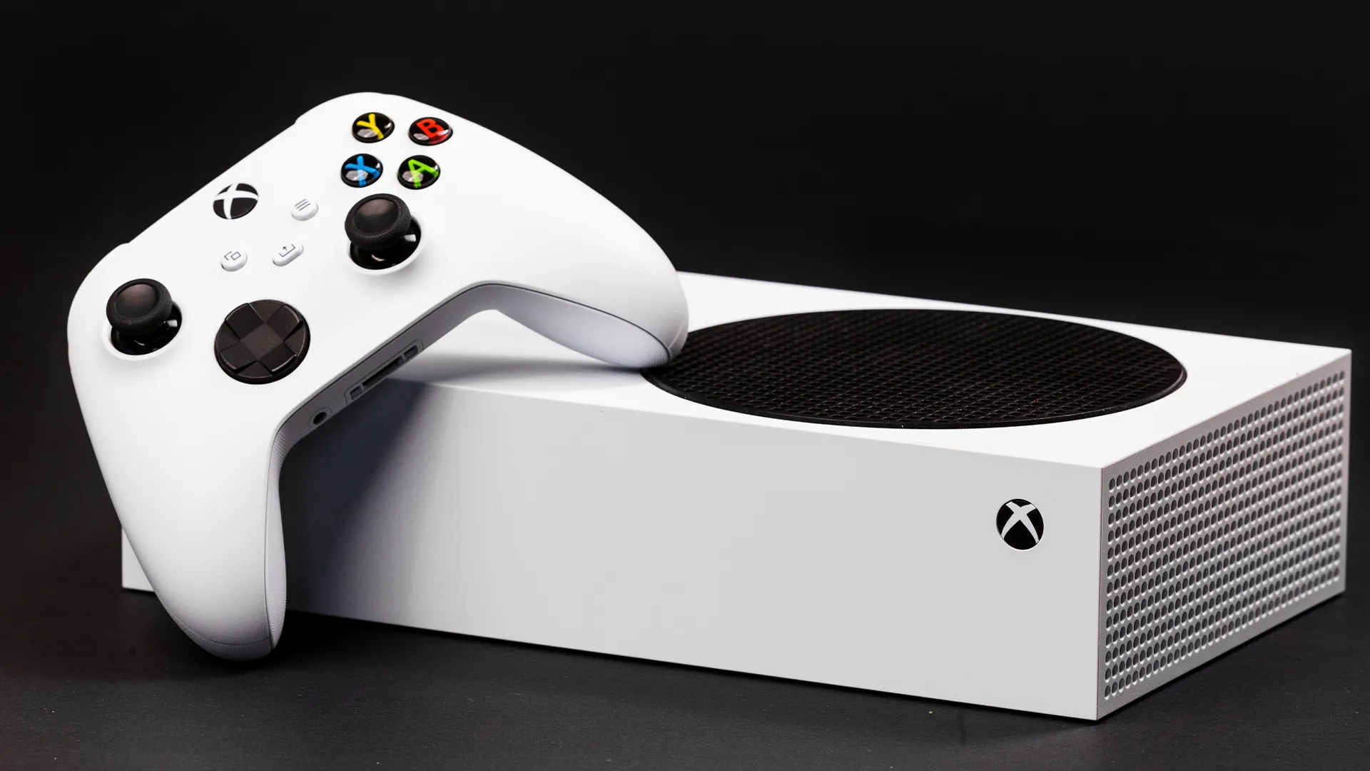 Máy chơi game Xbox Series S màu trắng đặt nằm ngang với bộ điều khiển Xbox Series, đại diện cho console không ổ đĩa