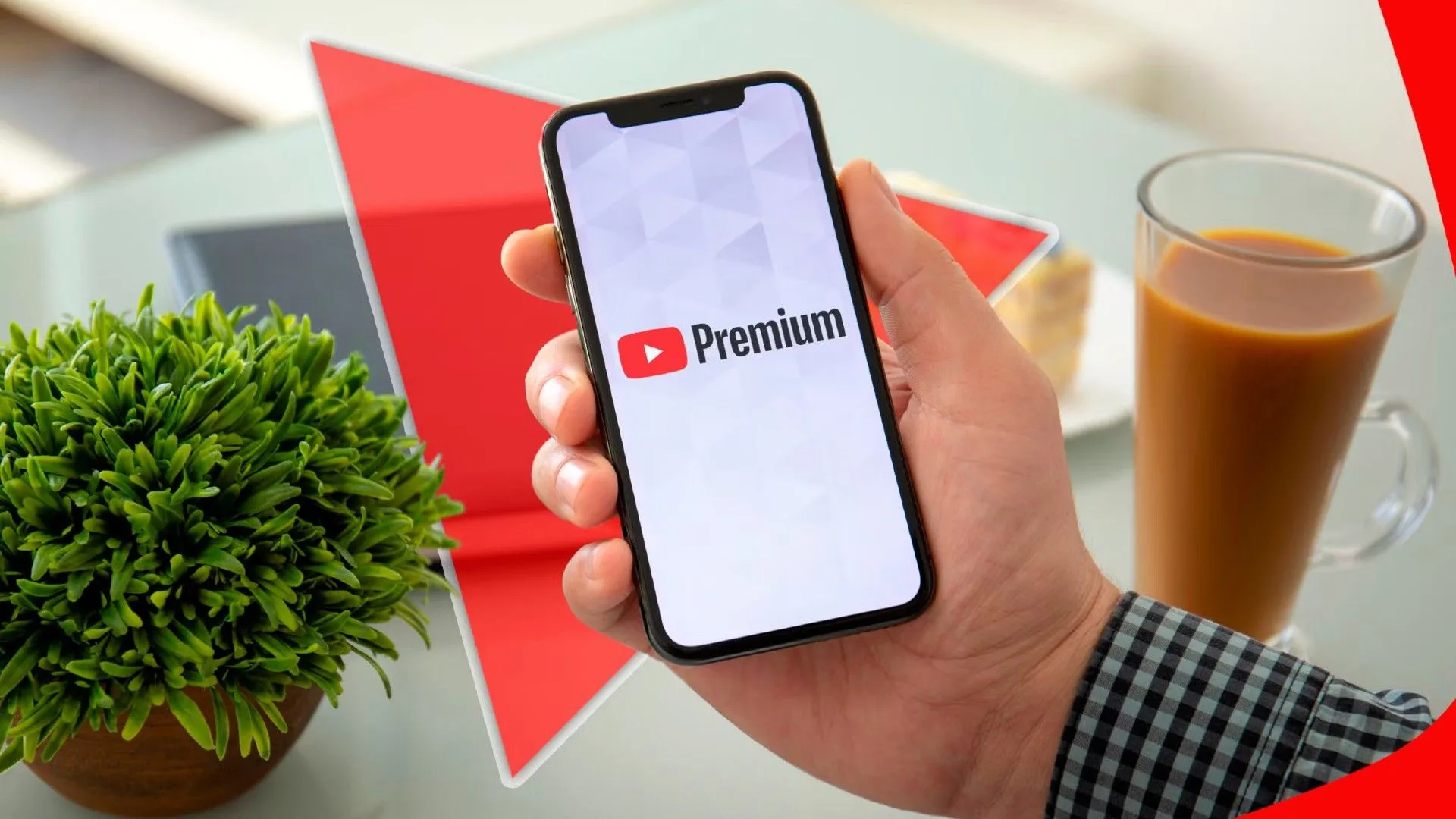 Một bàn tay cầm điện thoại với logo YouTube Premium trên màn hình