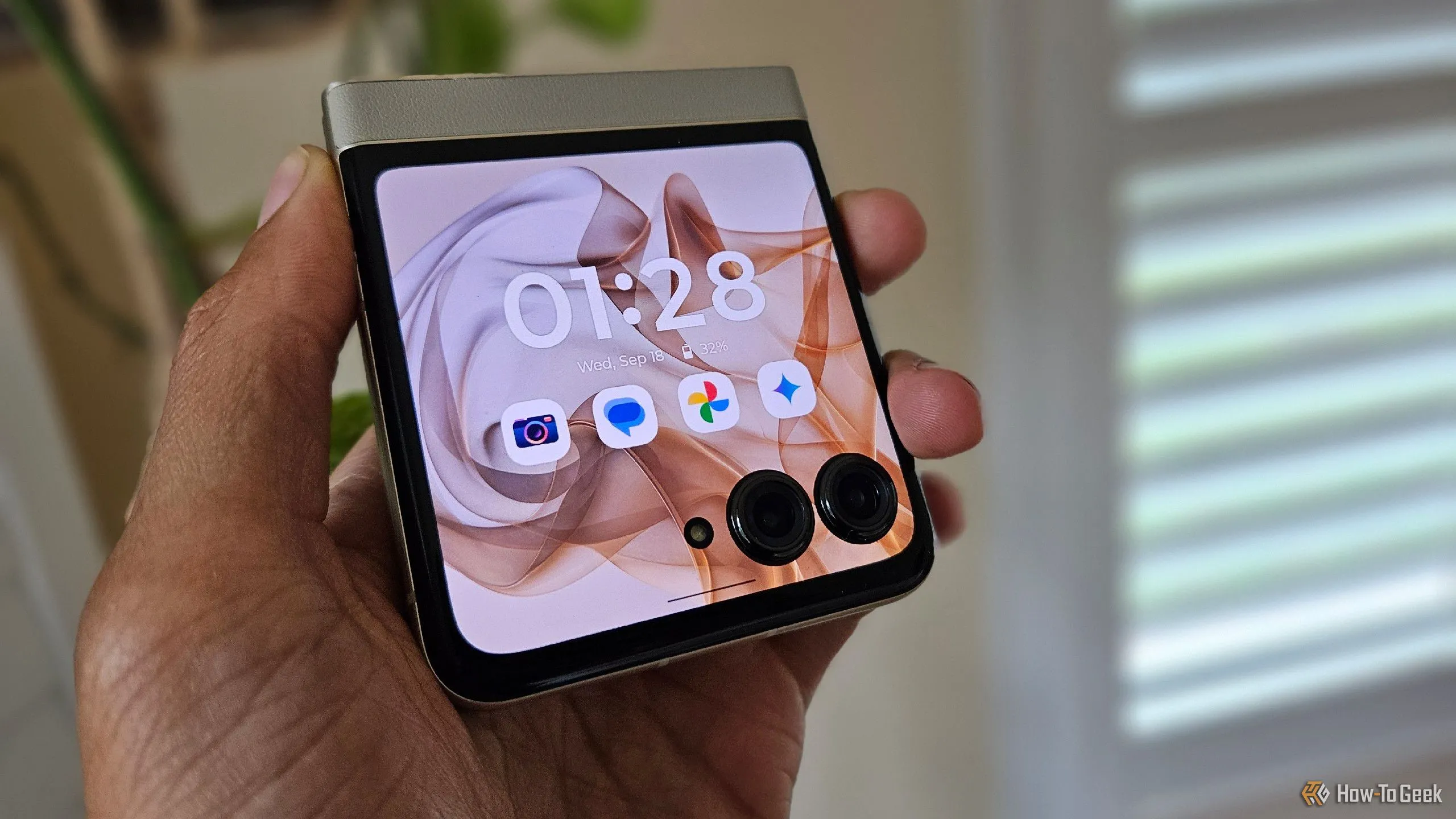 Một bàn tay đang cầm chiếc điện thoại Moto Razr 2024 gập gọn.