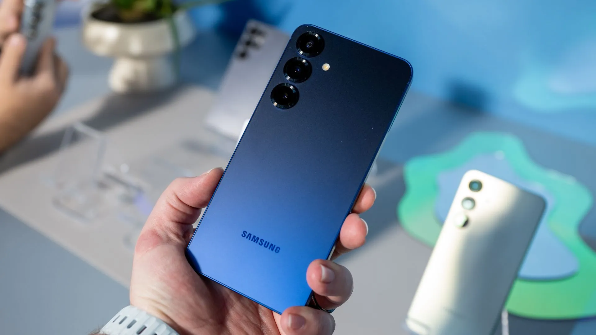 Người dùng cầm điện thoại Samsung Galaxy S25 màu xanh Navy, làm nổi bật thiết kế mỏng nhẹ của máy.
