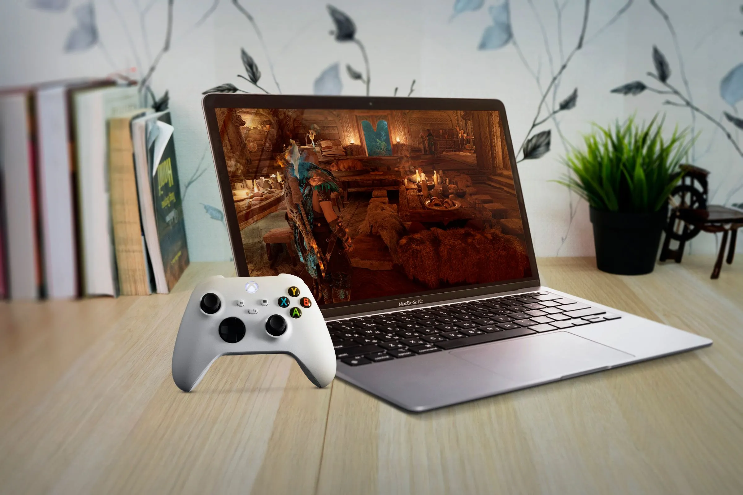Người dùng chơi game trên MacBook Air với tay cầm Xbox, minh họa thách thức đối với nhà phát triển game Mac