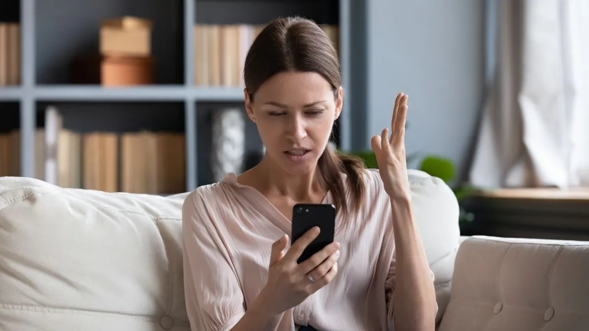 Người phụ nữ bối rối khi đọc bình luận trên điện thoại.