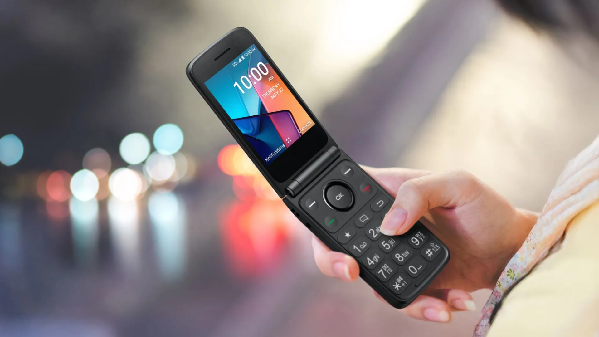 Người phụ nữ đang cầm điện thoại gập TCL Flip 4 5G màu xanh