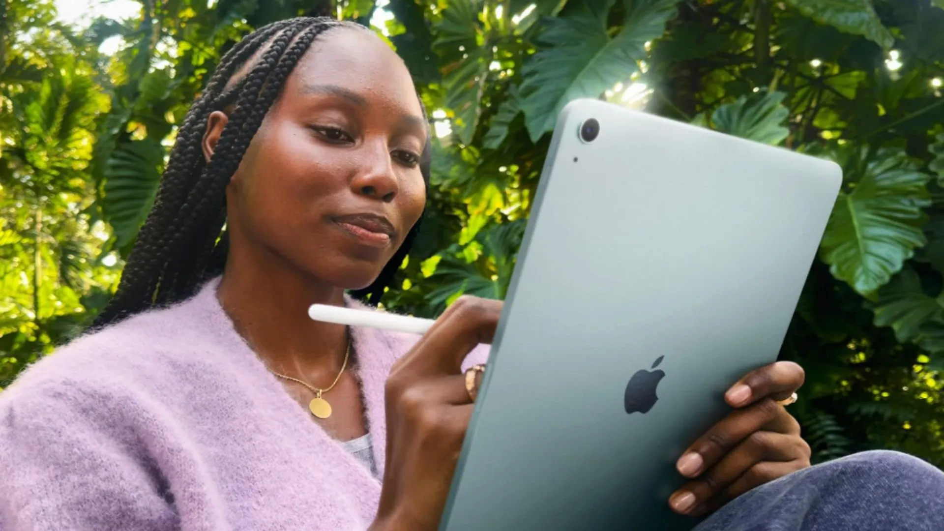 Người phụ nữ đang sử dụng Apple Pencil trên iPad Air M3 màu xanh