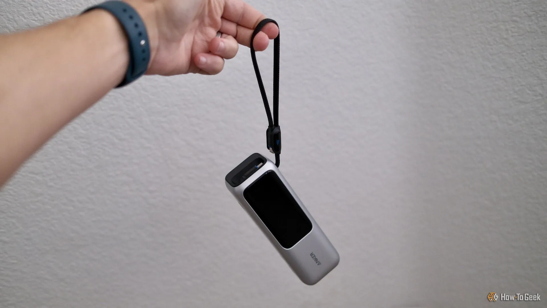 Sạc dự phòng Anker Power Bank 25K được cầm bằng dây đeo tích hợp, minh họa tính di động và tiện lợi.