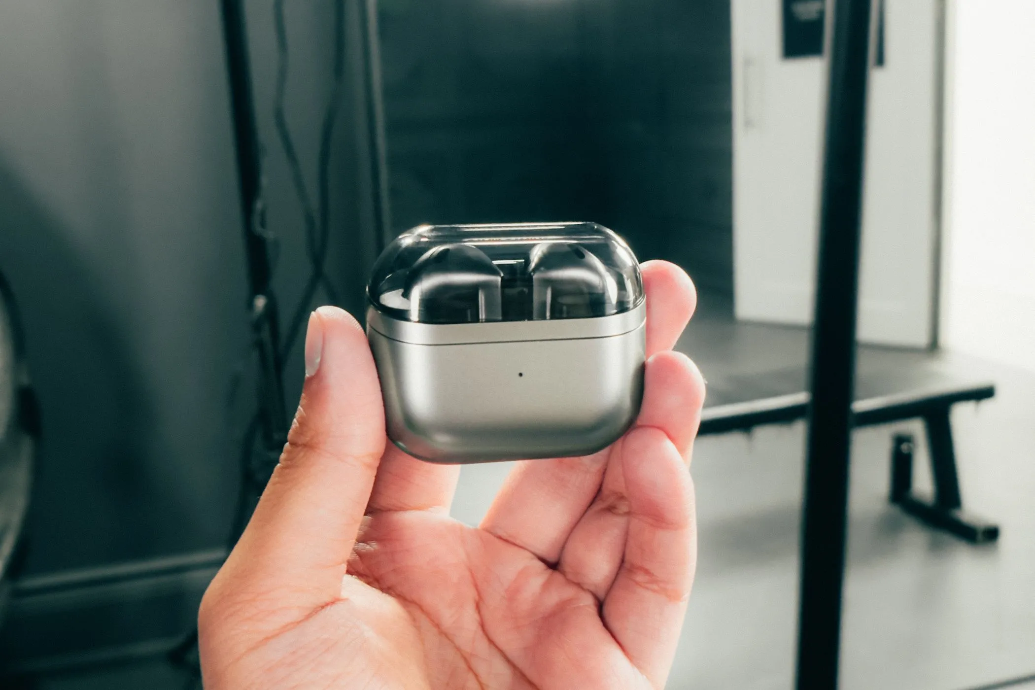 Tai nghe Samsung Galaxy Buds 3 trong hộp sạc đóng nắp, được cầm trên tay