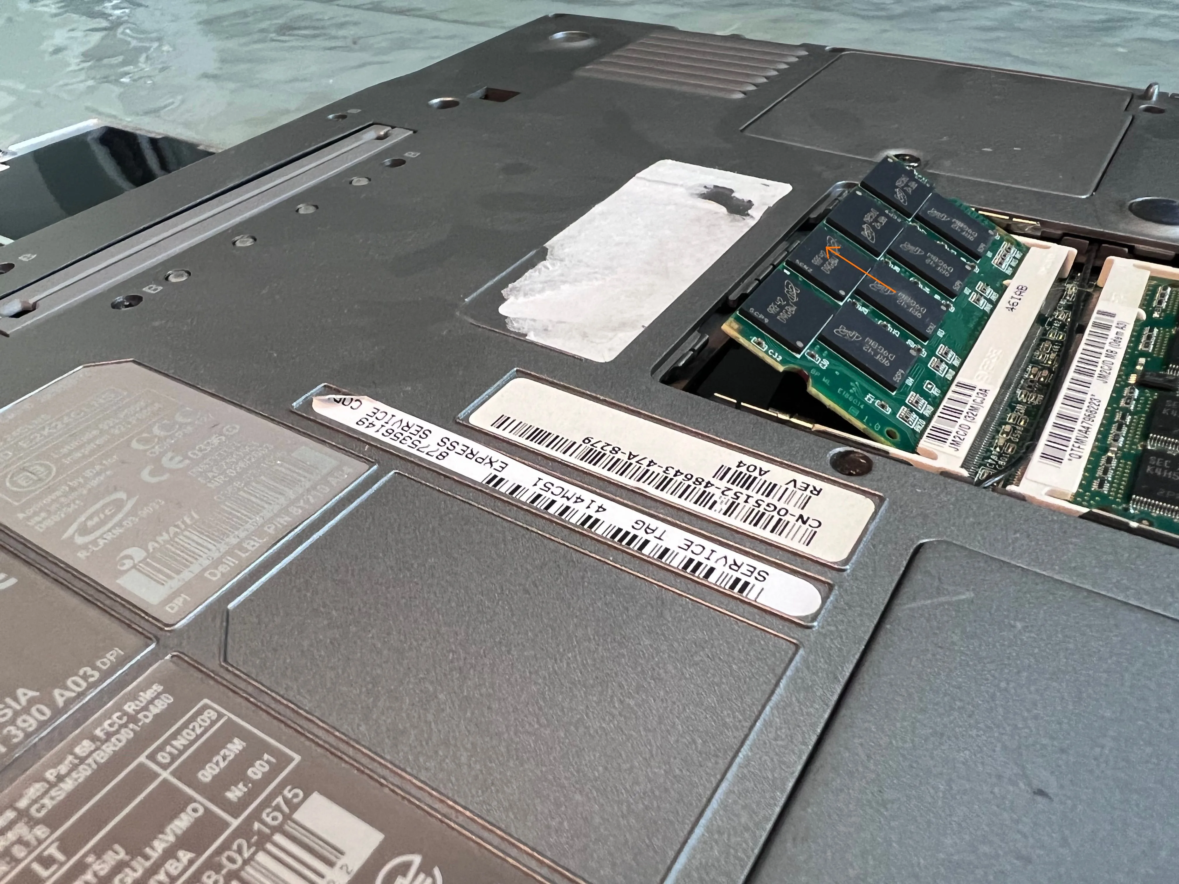 Thanh RAM trên laptop Dell đã được nhả lẫy và bật nhẹ lên, sẵn sàng để tháo ra.