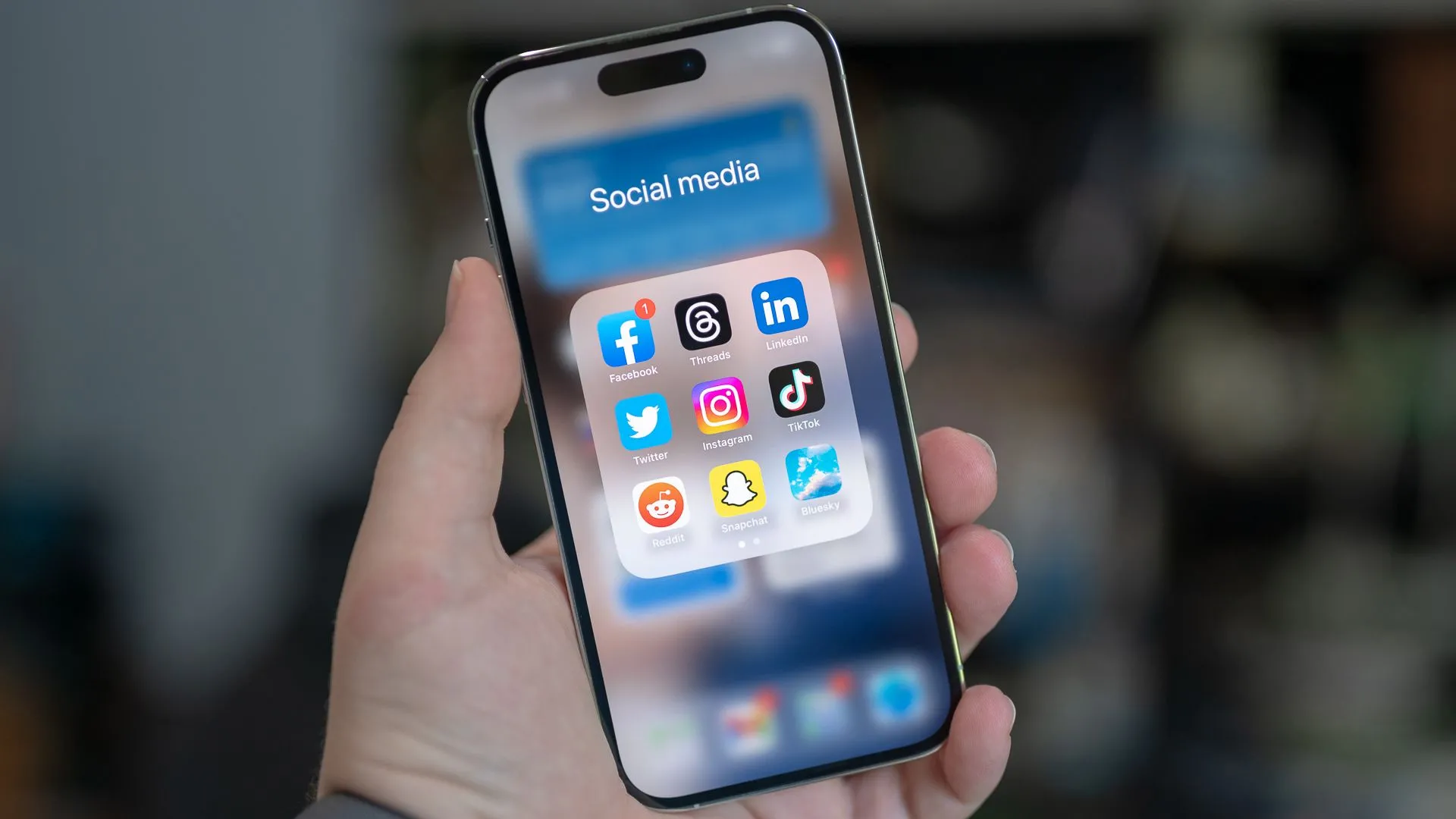 Thư mục chứa các ứng dụng mạng xã hội như Facebook, Threads, LinkedIn, X (Twitter), Instagram, TikTok, Reddit, Snapchat và Bluesky trên màn hình iPhone 14 Pro.