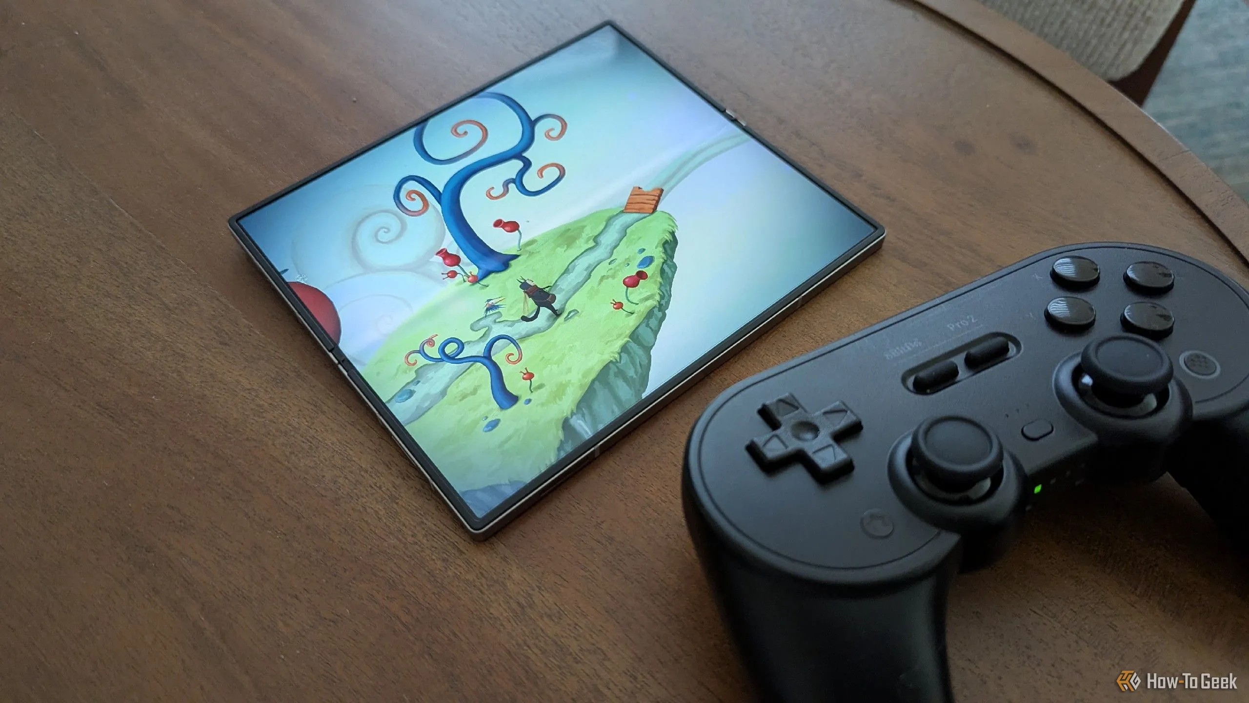 Tựa game Figment hiển thị trên Samsung Galaxy Z Fold 6 cùng với tay cầm chơi game 8BitDo Pro 2, minh họa khả năng chơi game chất lượng cao trên di động.